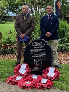 Volunteers for the Commonwealth War Graves stood at one of the graves decorated with wreaths made of poppies